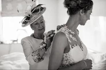 Black and white — mother fastening bride's dress