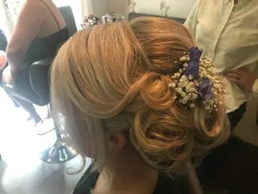 Bridal updo with purple floral accessories